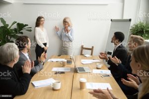 Senior Woman Boss Introducing New Worker Team At Meeting